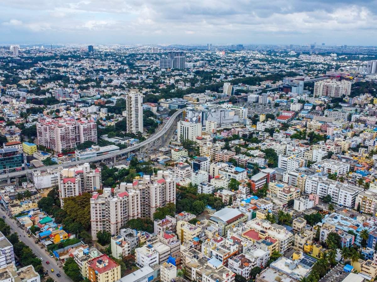 An aerial view of Bangalore, with an elevated flyover curving through the city
