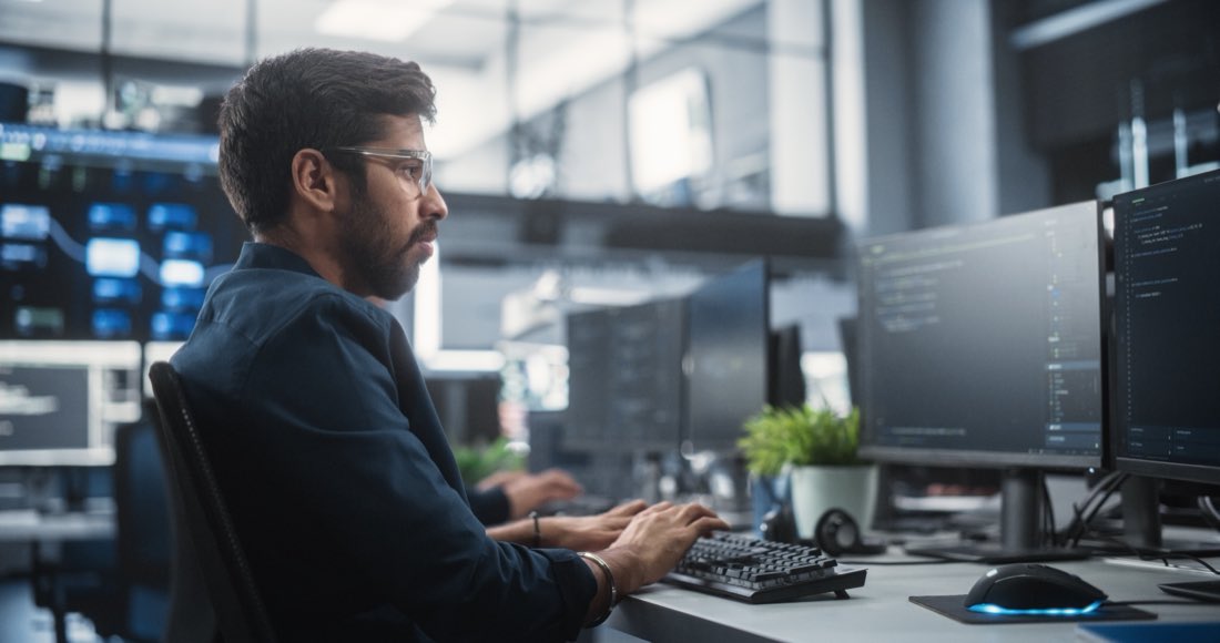 An engineer writing code at a workstation
